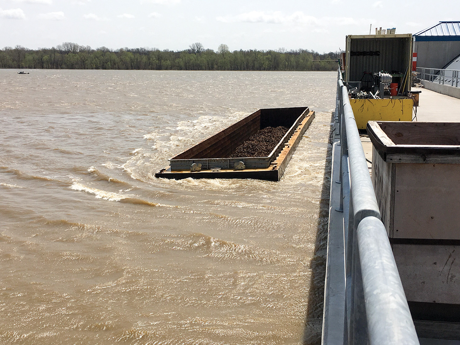 A barge lodged adjacent to the Olmsted Locks and Dam is one of six that broke loose from a tow.