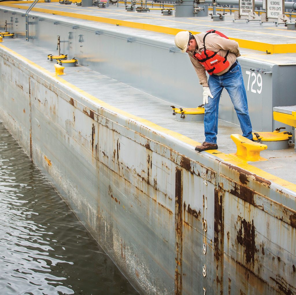 PSC Tankerman Paul Fox monitors drafts while loading a barge. (Photo courtesy of Petroleum Service Corporation)