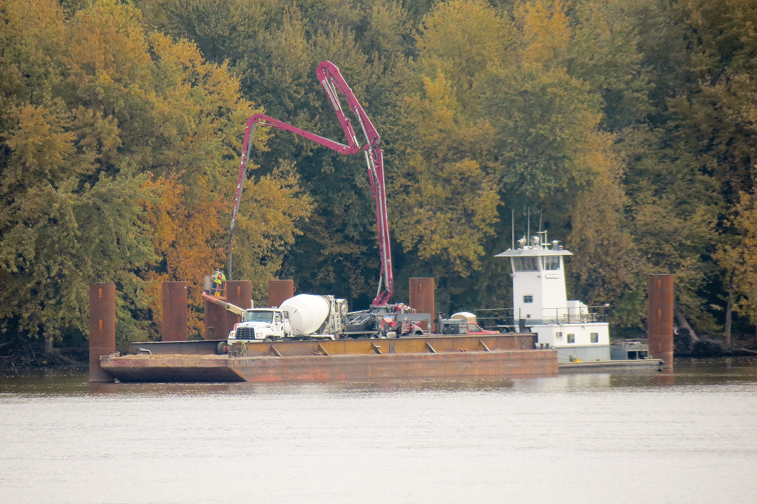 The towboat Ajay pushing a deck barge and crane from Wayne B. Smith Inc. (WBS), which pours concrete into four steel piers for the SIMCO grain terminal in Pike County, Ill., before they were capped with welded steel plates. The pouring operation took a day. WBS also provided placement of the 42 D-rings on the mooring cells. The next step is building a loadout tower on top of the middle four cells, said Greg Dolbeare.
