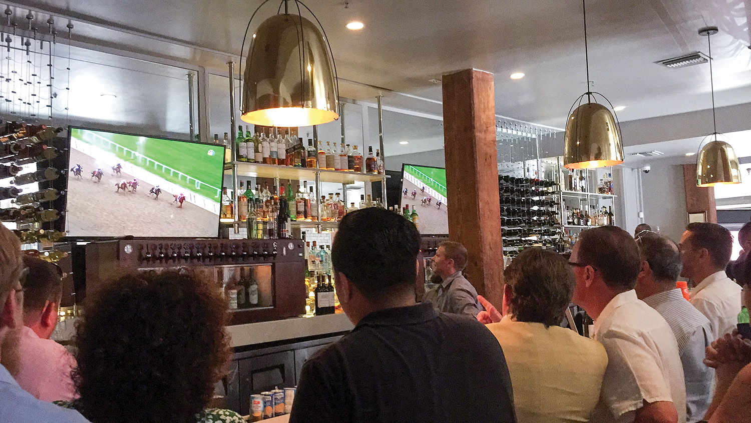 Turn Services friends and employees watch the Belmont Stakes at NOSH in New Orleans, waiting to see if Justify will win the race and the Triple Crown. (Photo by Jen McCormack)