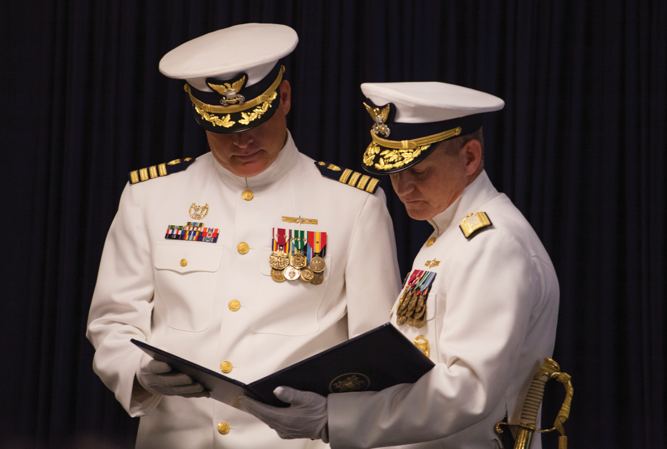 Rear Adm. Paul Thomas (right), commander of the U.S. Coast Guard’s Eighth District, presents a meritorious service medal to Capt. Wayne Arguin, Sector New Orleans’ outgoing commander, for his leadership at the sector, which included the 2016 response to historic rains that flooded much of the Baton Rouge and Denham Springs areas.