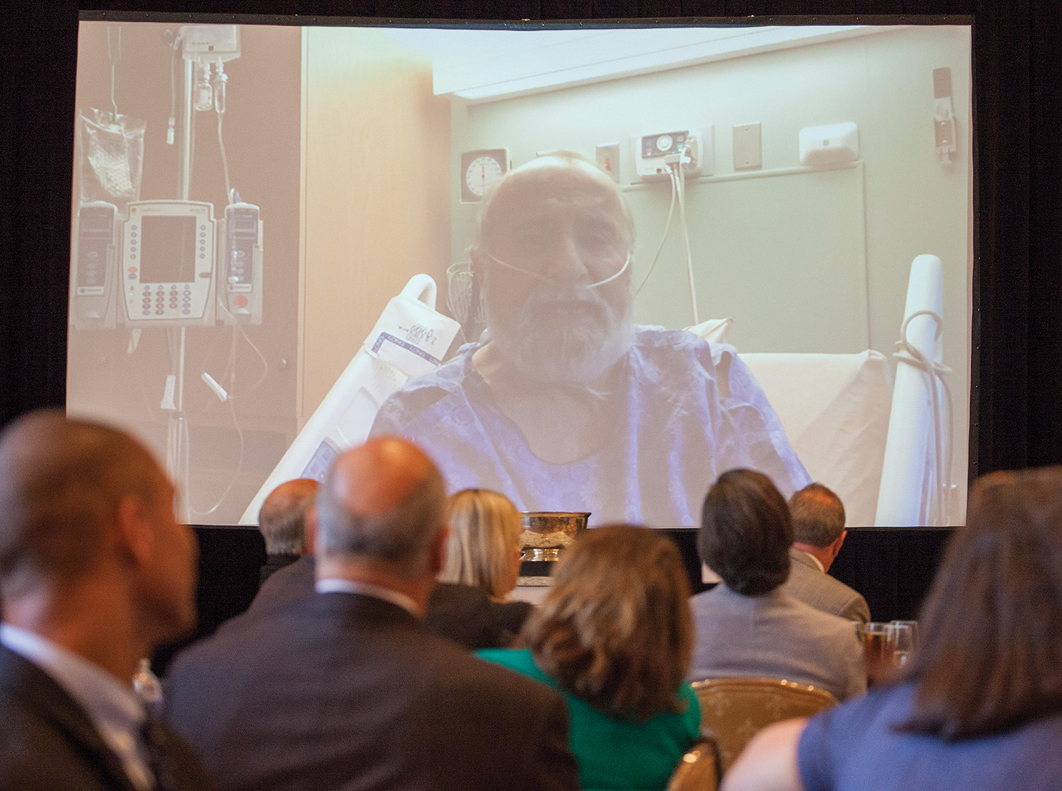 Bill Bergeron addresses the crowd gathered for the C. Alvin Bertel Award luncheon from his room at Ochsner Medical Center. (Photo by Frank McCormack)