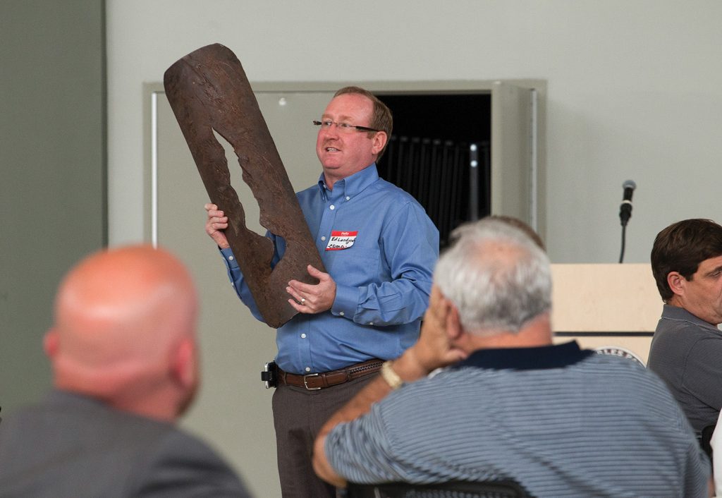 Ed Landgraf, chairman of CAMO, holding a portion of a pipeline that had seen a vessel impact. (Photo by Frank McCormack)