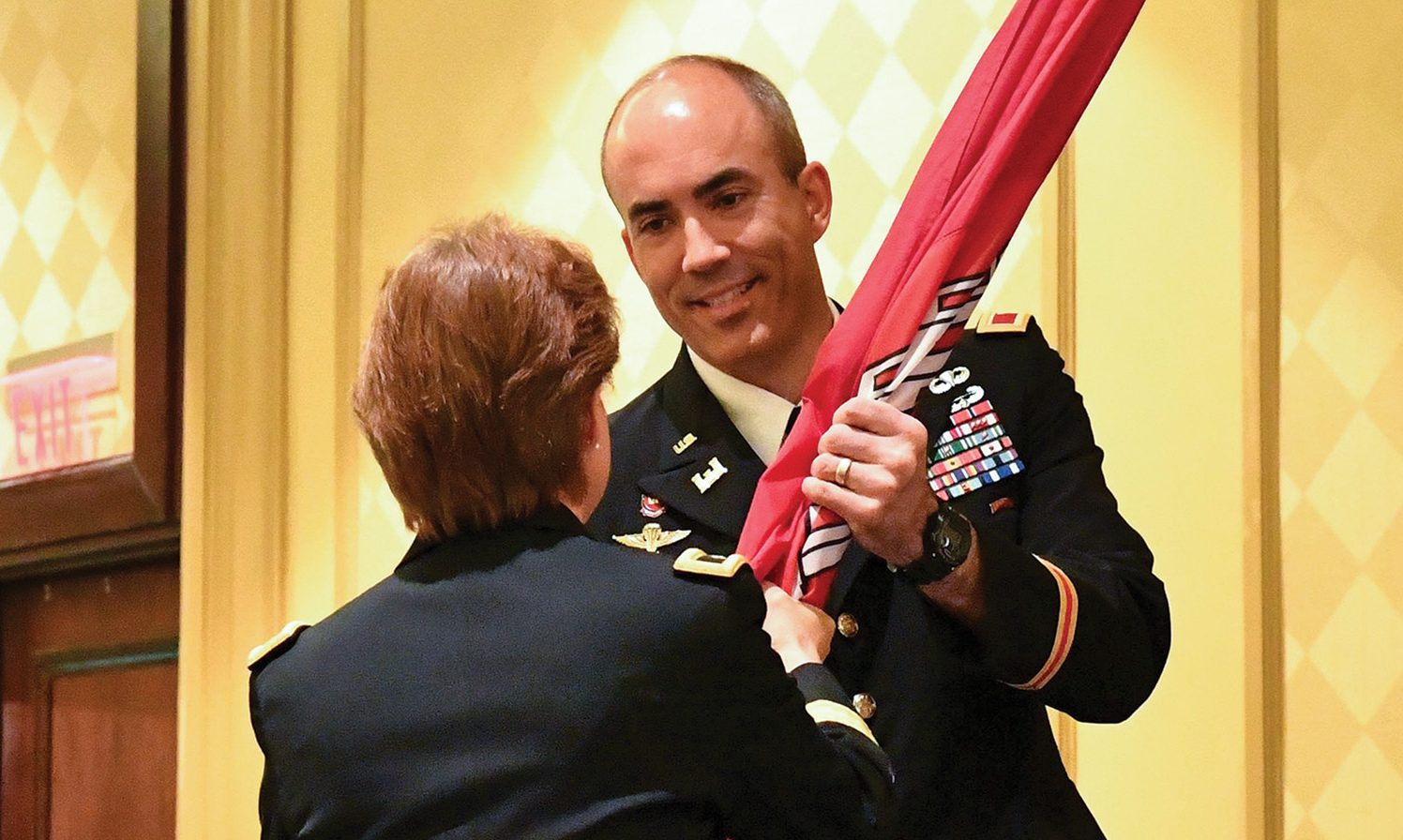 Col. Sebastien Joly receives the U.S. Army Corps of Engineers flag from Brig. Gen. Diana Holland during the Mobile Engineer District change-of-command ceremony. Joly became the 53rd commander of the Mobile District. (Corps of Engineers photo by Chuck Walker)