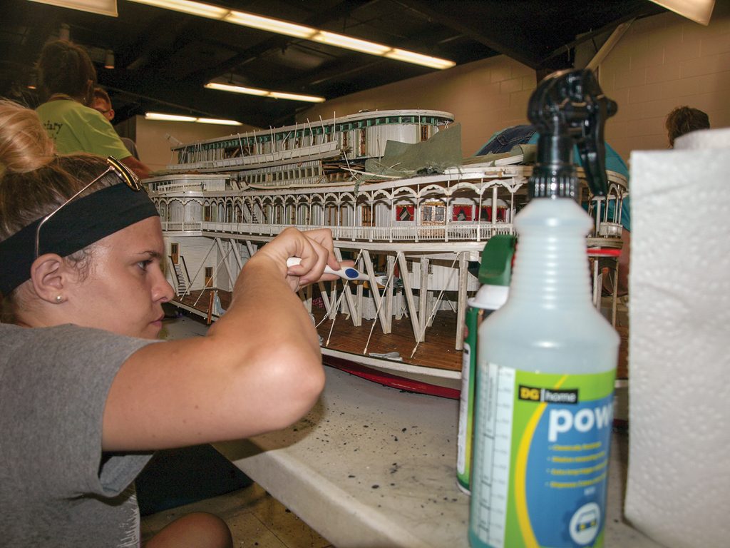 —photo by Jim Ross Conner Grady of Point Pleasant cleans a steamboat model that was damaged in the fire. (Photo by Jim Ross)