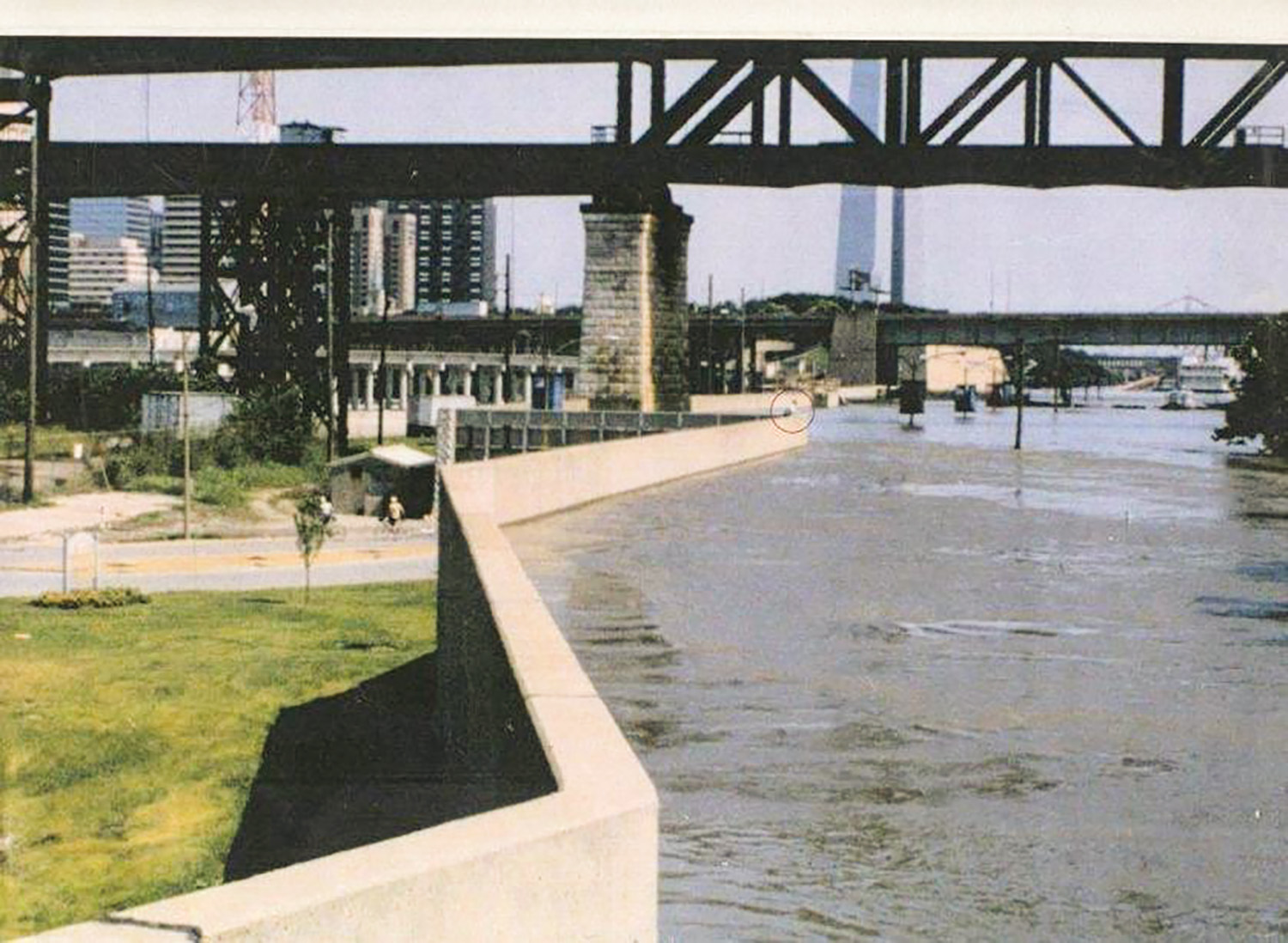 Left: Note the person circled in red standing at the St. Louis floodwall taken from the top of the Mill Creek Pumping Station, near the intersection of Chouteau Ave. and Wharf Street/Leonor K. Sullivan Blvd. looking upstream. (Photo courtesy of St. Louis Engineer District)