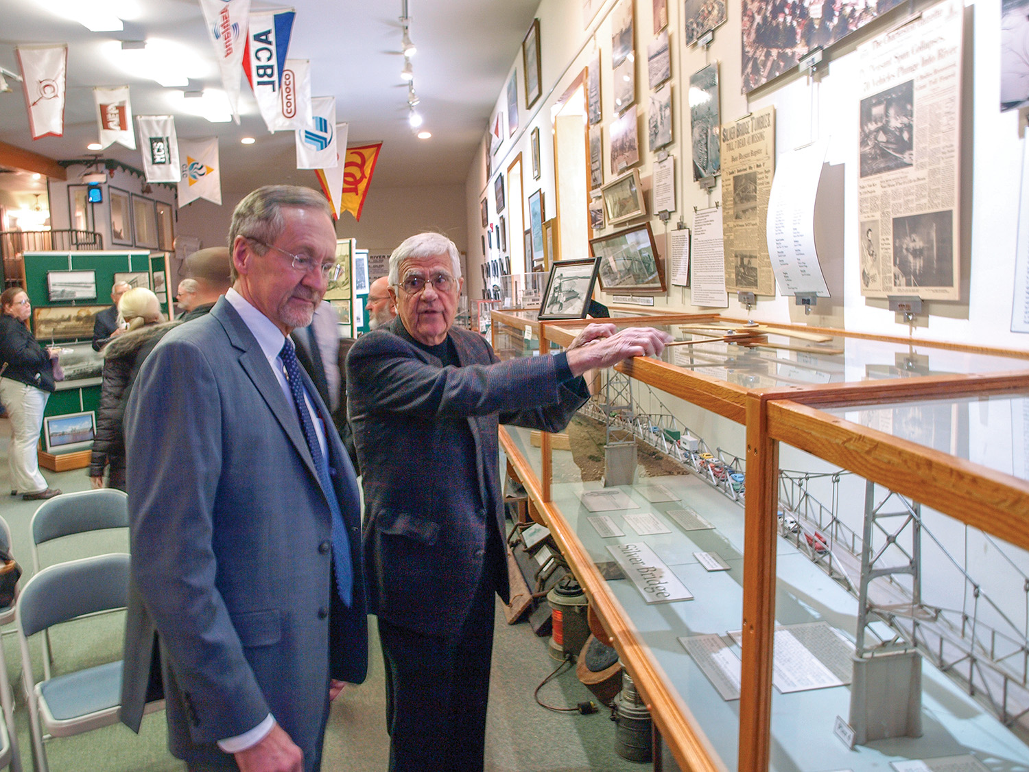 Jack Fowler, right, executive director of the Point Pleasant River Museum and Learning Center, talks about the Silver Bridge collapse with Tom Smith, West Virginia secretary of transportation, at a reception at the museum before the 50th anniversary memorial ceremony for the bridge collapse on December 15. (Photo by Jim Ross)