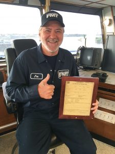 Capt. Joe Kent of the mv. Ron Hull holding the boat’s COI.