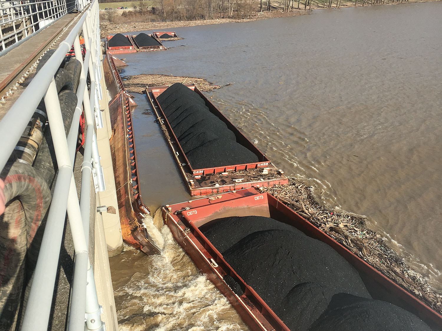 Barges lodged against McAlpine Dam. (Coast Guard photo by Petty Officer 3rd Class Travis Magee)