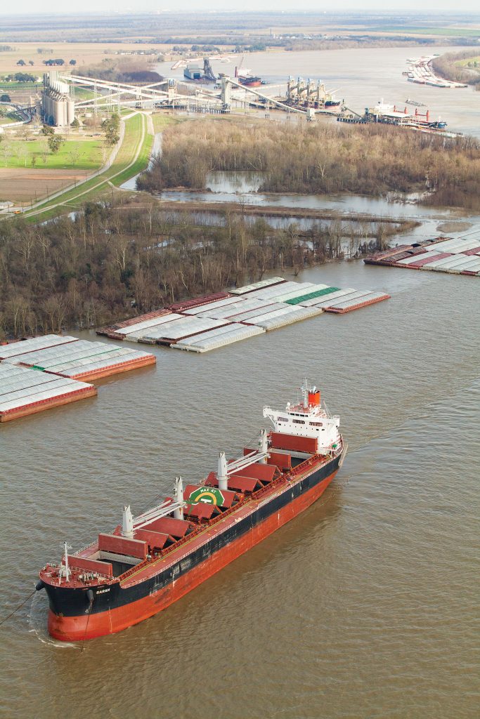 Fleets near Welcome and Convent, La., as well as both the Zen-Noh grain elevator (one of seven grain elevators within the Port of South Louisiana) and a conveyor leading from Nucor Steel’s direct reduced iron plant. (Photo by Frank McCormack)