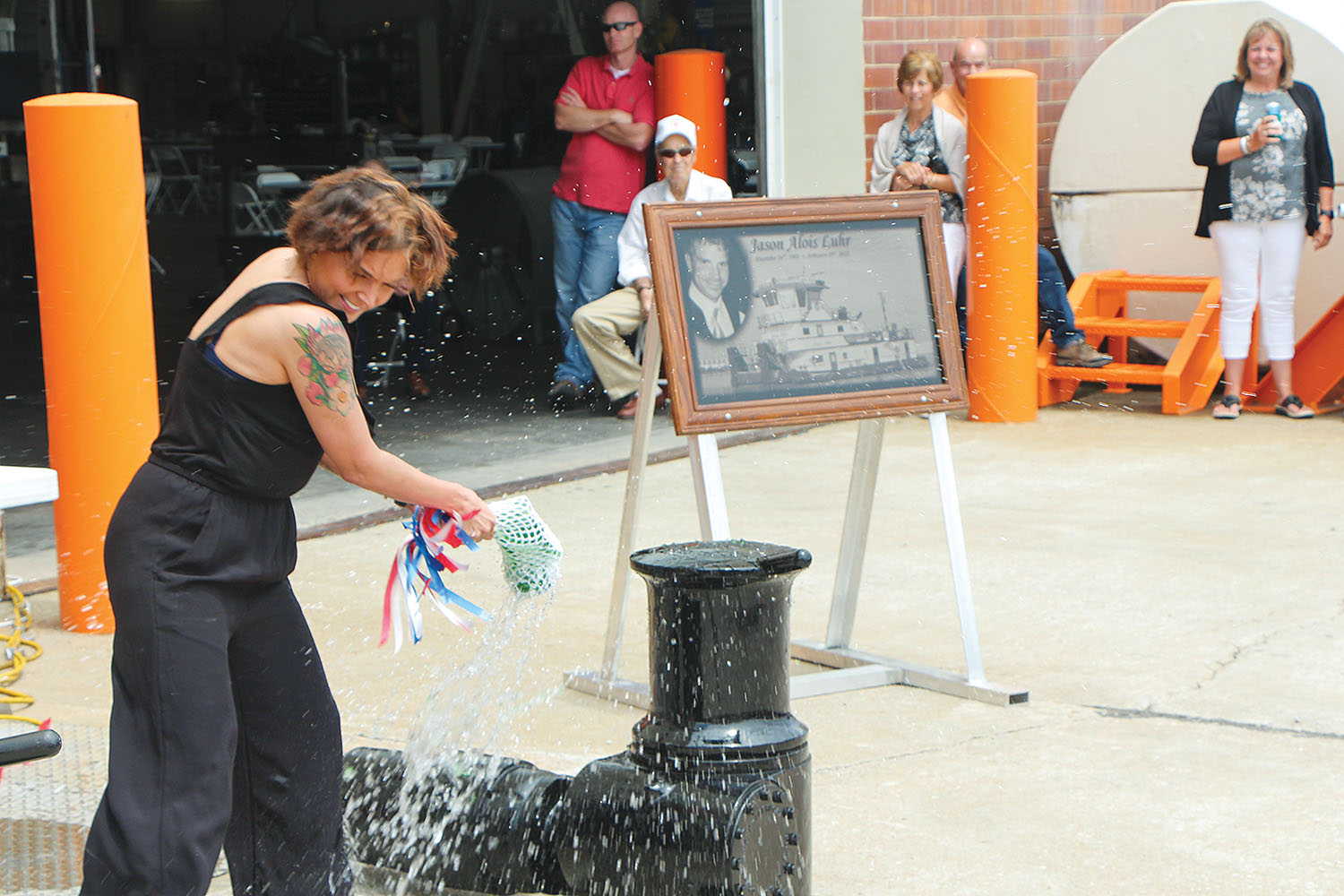 Kacie Maxwell breaks champagne bottle over mock-up of mv. Jason Luhr. (Photo by H. Nelson Spencer)