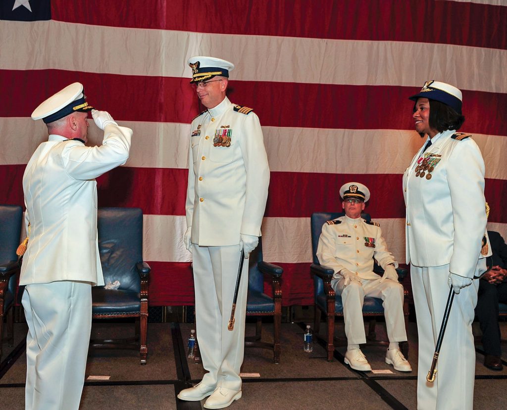 Cmdr. Randy Preston (left) acknowledges Capt. Thomas Stuhlreyer, commander, Sector Lake Michigan, at a change-of-command ceremony at the Union League Club of Chicago, during which Preston assumed command of Marine Safety Unit Chicago. Preston relieved Cmdr. Zeita Merchant, right, who will transfer to Harvard University where she will serve as a National Security Fellow at Harvard Kennedy School’s Belfer Center for Science and International Affairs. (U.S. Coast Guard photo by Master Chief Alan Haraf)