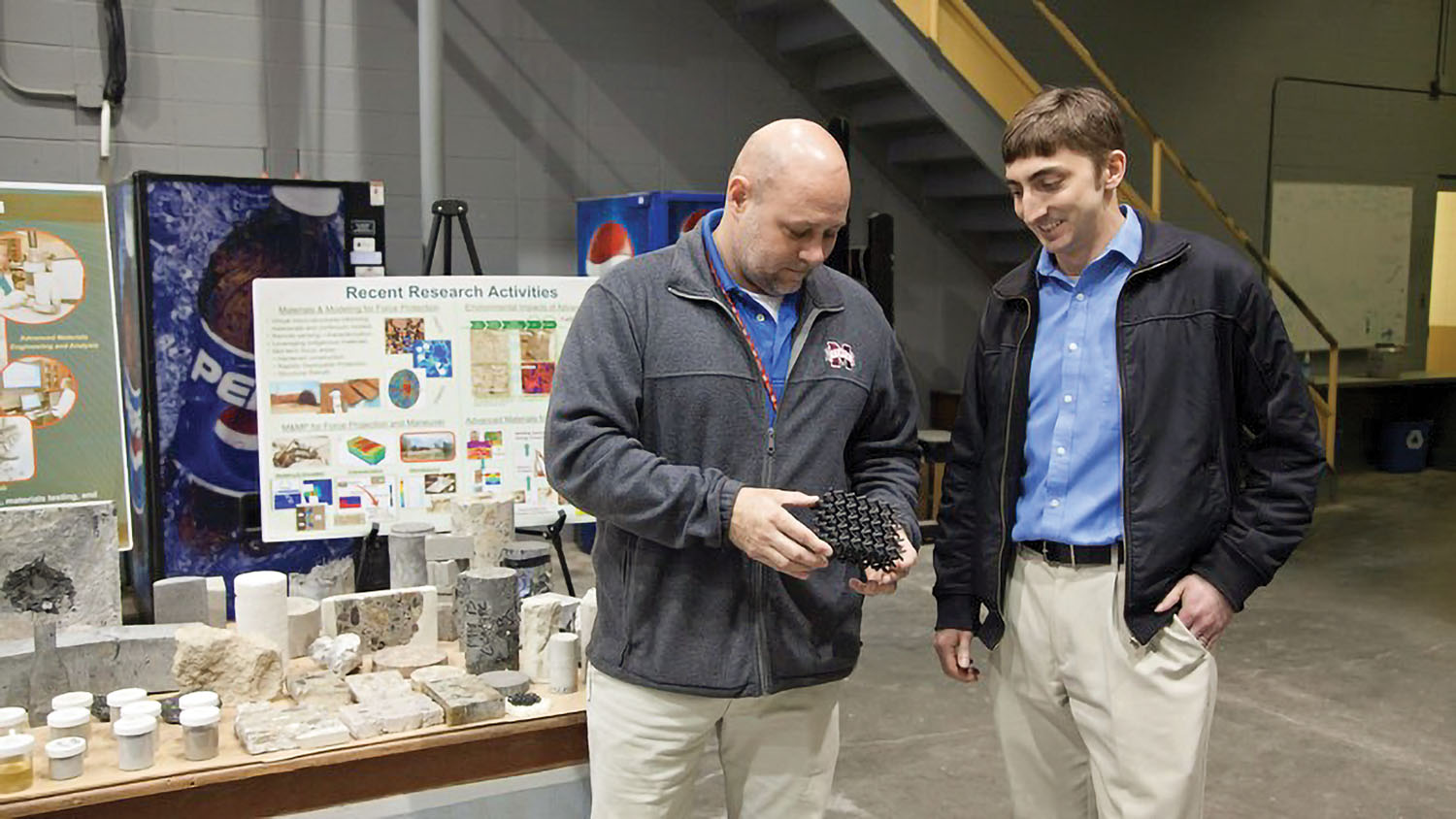 Brian Lucarelli, right, a civil engineer in the Pittsburgh Engineer District, tours the Geotechnical and Structures Laboratory at the U.S. Army Engineer Research and Development Center in Vicksburg, Miss. At left is the lab’s Concrete and Material Branch Chief Christopher Moore, who is holding a sample of  polylactic acid material, which is 3-D printed into a lattice structure to enhance structural performance and energy dispersion.