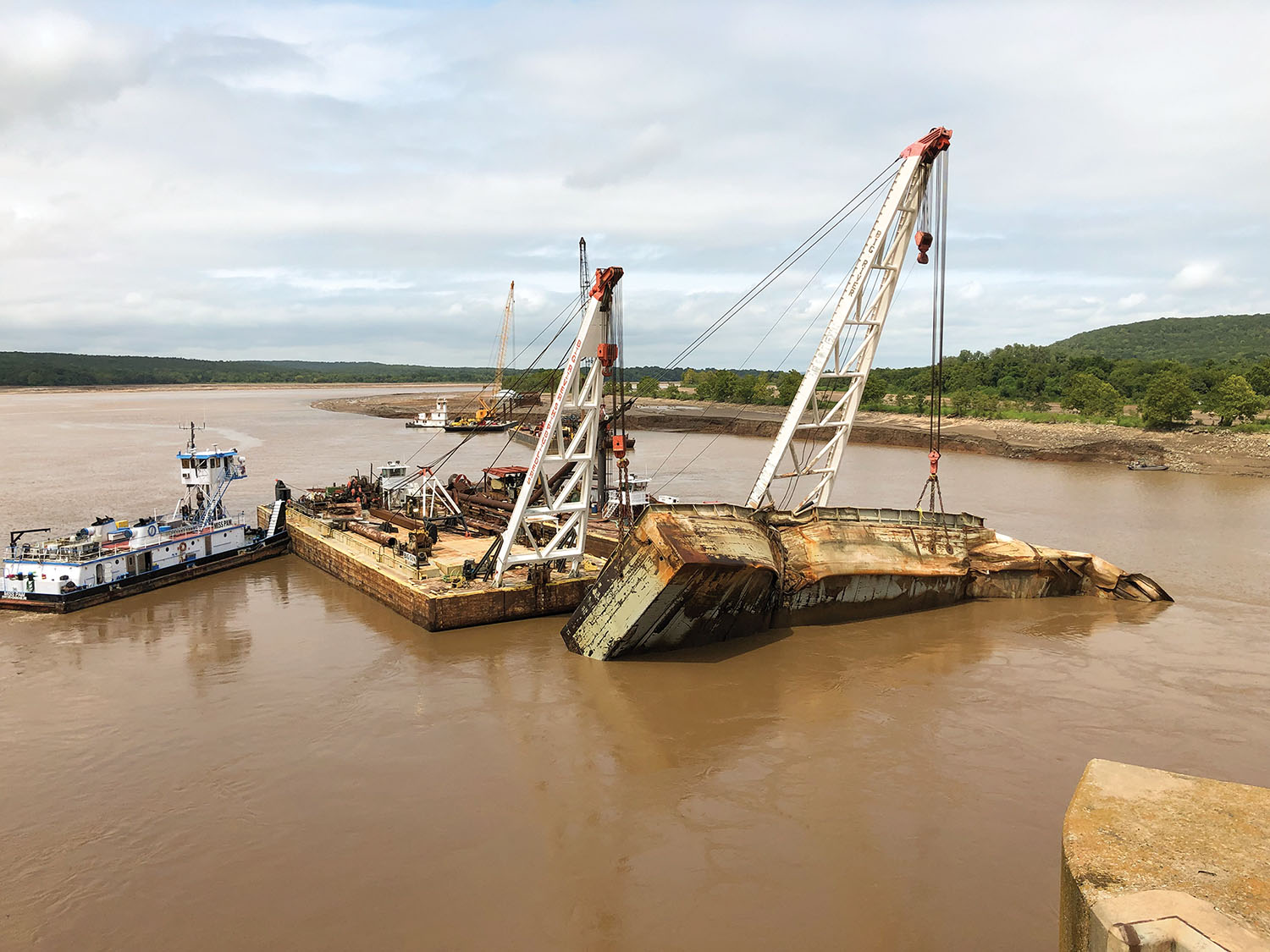 Salvaged barge is moved upstream where it will be cut up for scrap. (Photo courtesy of Tulsa Engineer District)