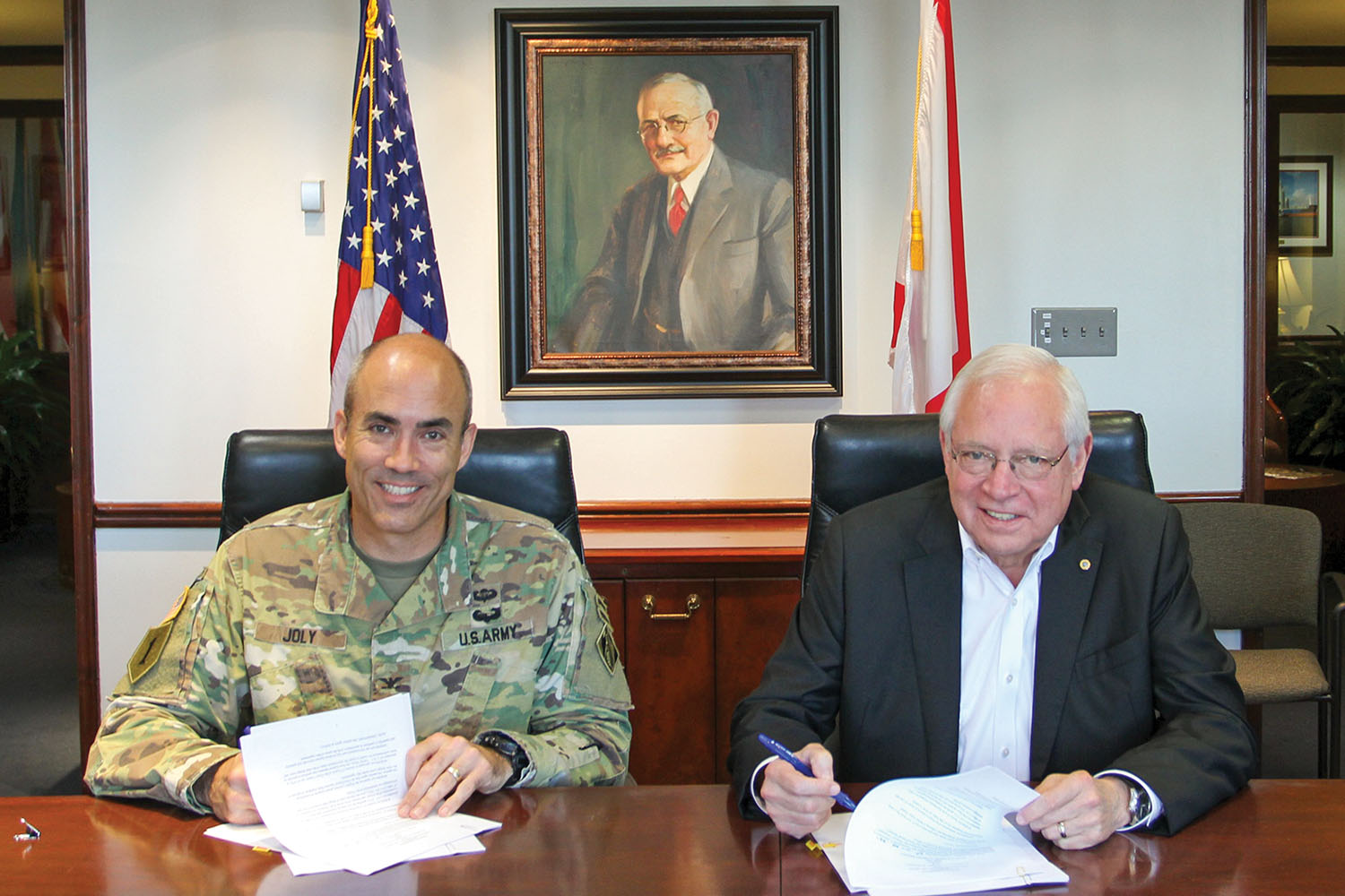 Col. Sebastien Joly and James Lyons sign PED agreement at the Alabama State Port Authority’s headquarters. (Photo courtesy of Alabama State Port Authority)