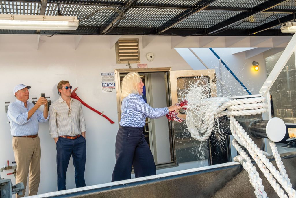 Louise “Ouizee” Brooks smashes a champagne bottle to christen the mv. Ouizee. (Photo courtesy of Maritime Partners)