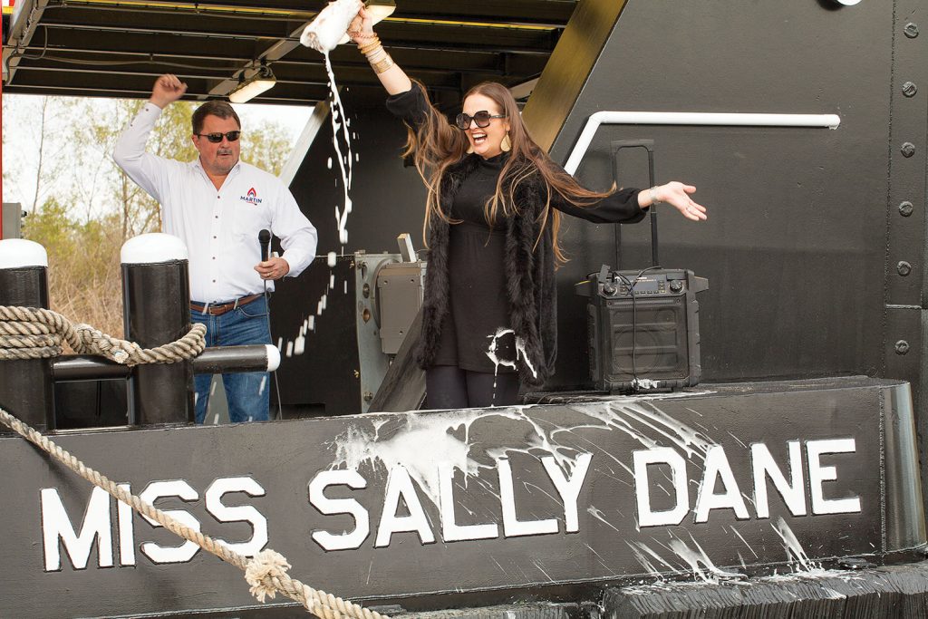 Sally Dane Sperry christens the boat named in her honor, while Rick Freed, vice president of Martin Marine, looks on. (Photo by Frank McCormack)