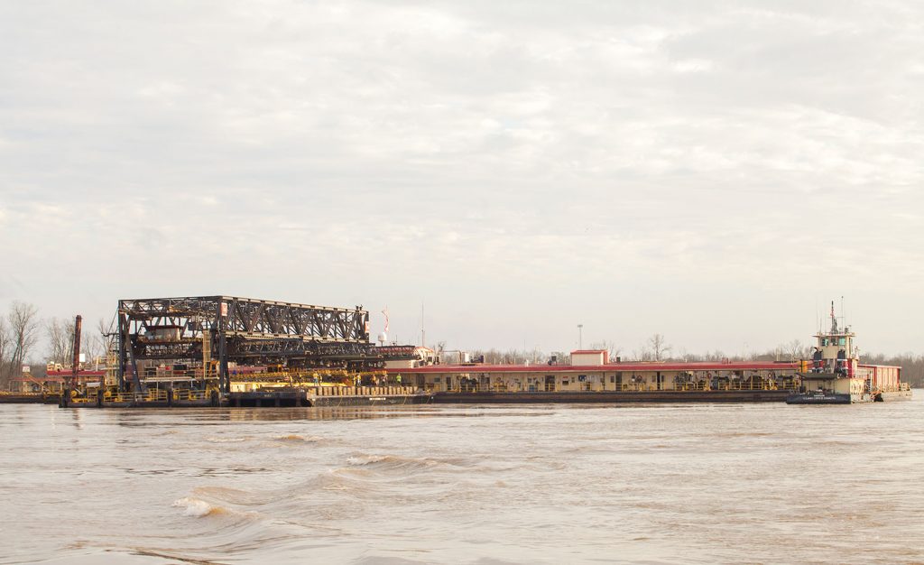 The U.S. Army Corps of Engineers’ Mat Sinking Unit at work on the west bank of the Lower Mississippi River near Donaldsonville, La. The unit consists of the mat laying barge (left), a floating plant (right), an anchor barge, a quarter barge and other support vessels. (Photo by Frank McCormack)