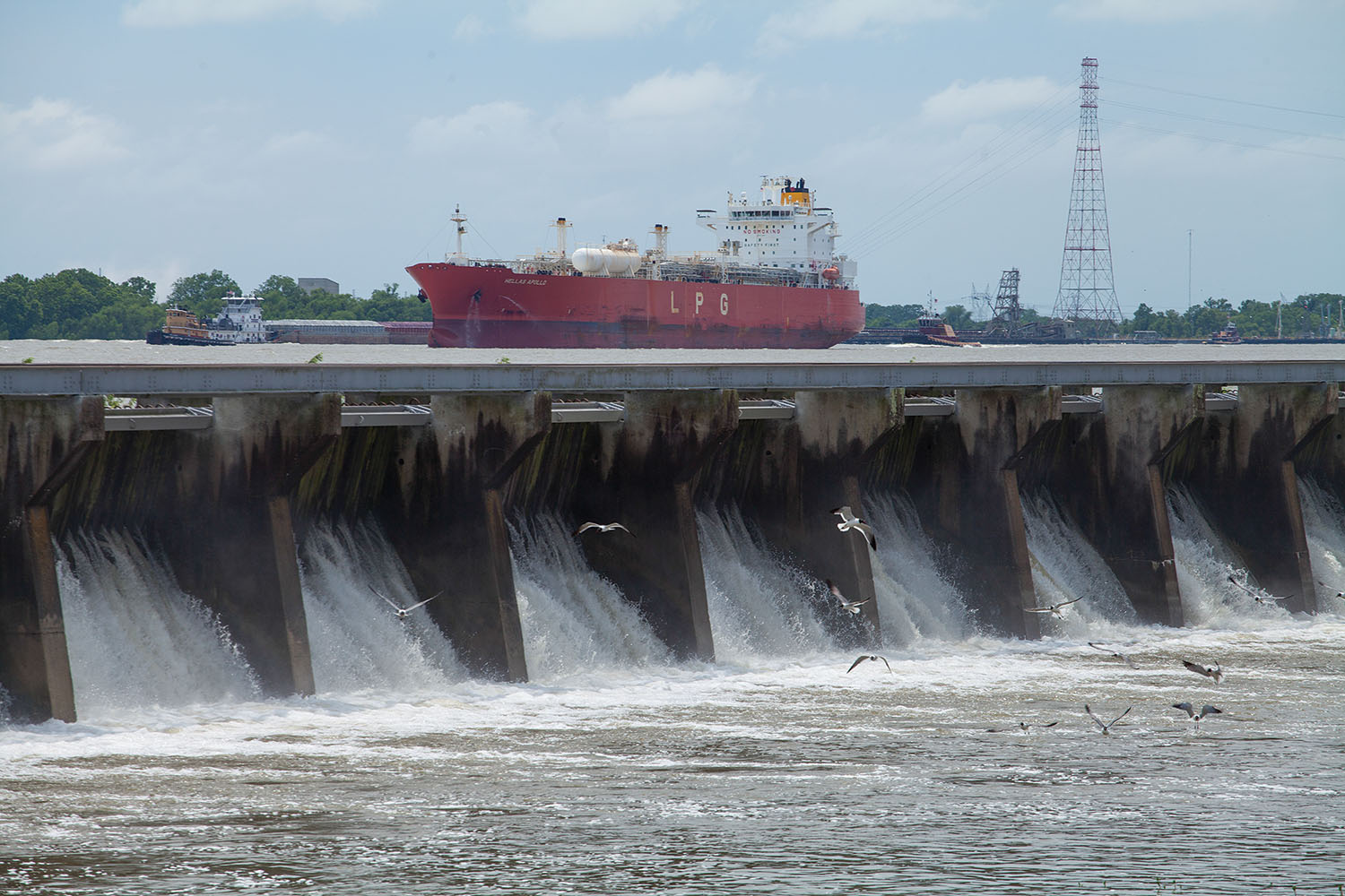 A tanker on the Mississippi River passes the Bonnet Carré Spillway in May 2019, during one of the spillways two high-water openings that year. (Photo by Frank McCormack)