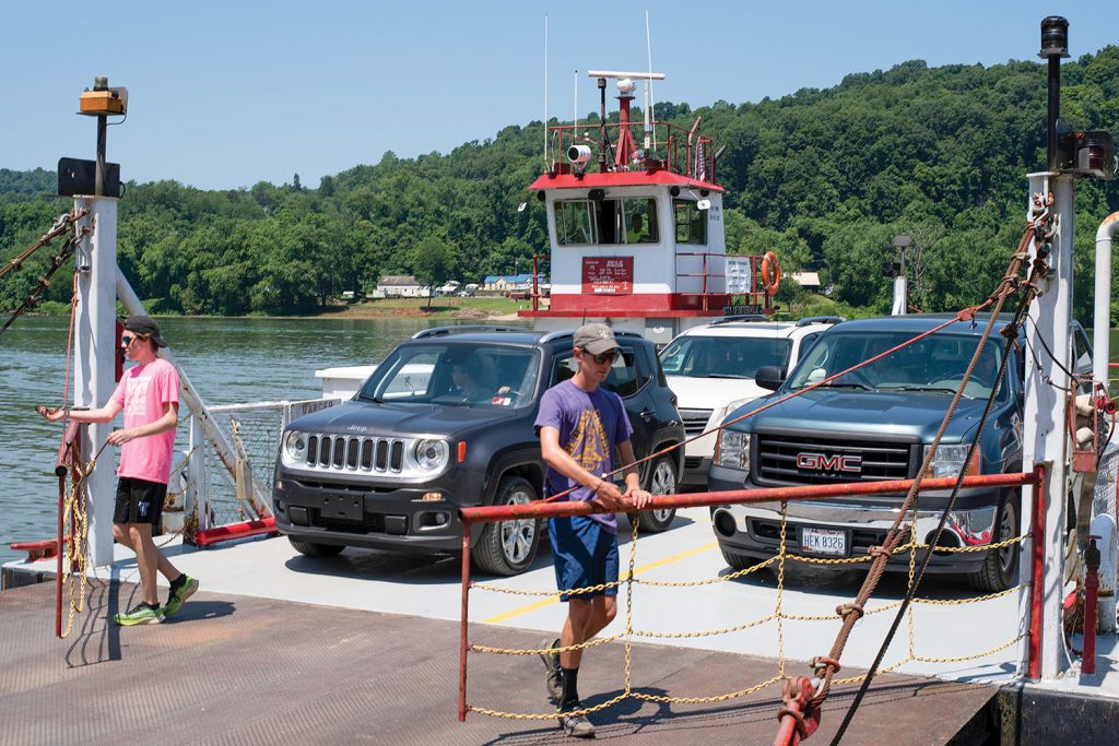 Deckhands James Street, left, and Spencer Corley open the gates to allow traffic off the ferry at Sistersville, W.Va. (Photo by Jim Ross)