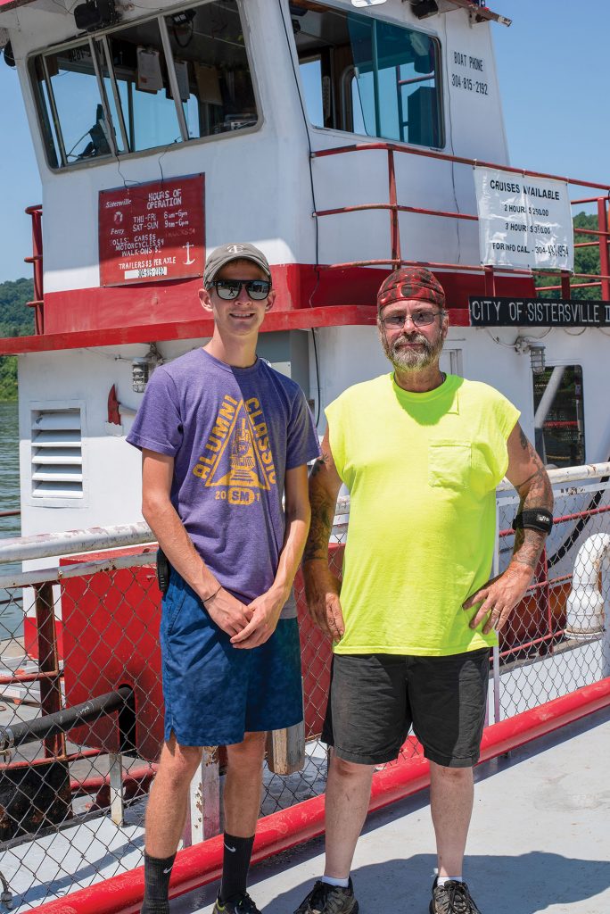 Capt. Bo Hause, right, pilots the Sistersville ferry. He hopes he can have his grandson, Spencer Corley, hired as a deckhand so he can learn how to run the service someday. (Photo by Jim Ross)