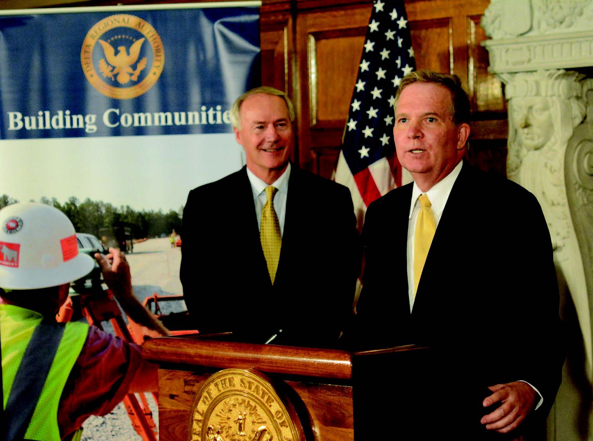 —Helena Harbor Helena Harbor port director John Edwards thanks Gov. Asa Hutchinson in 2017 for helping with a grant to the port as the governor looks on.