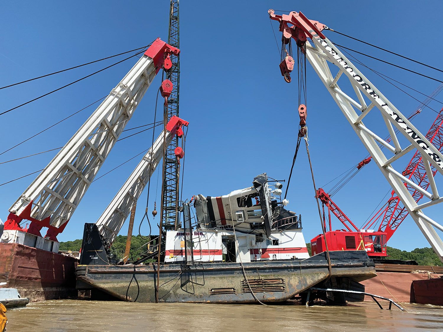 An Okie Moore Diving and Marine Salvage rig hoists the mv. Boone from where it sank at Upper Mississippi River Mile 43. An unknown passing tow apparently did damage to the wheelhouse, and the Boone had rolled onto its side, making it more difficult to recover.