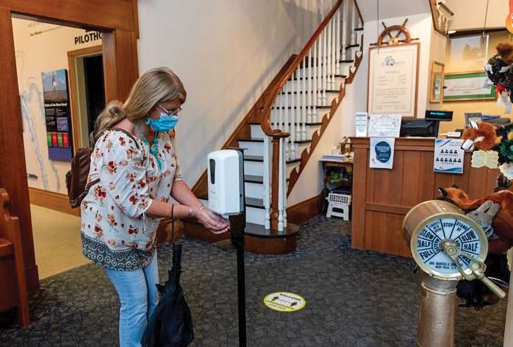 A masked visitor uses a touchless hand sanitizer station at the River Discovery Center in Paducah, Ky. (Photo courtesy of River Discovery Museum)