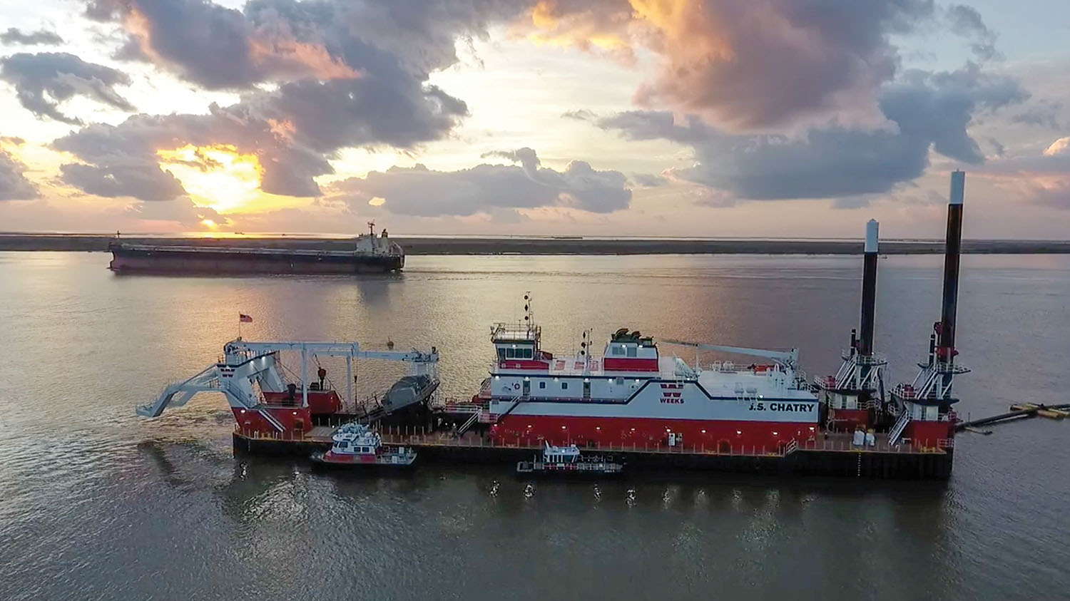 A ship passes the Weeks Marine cutterhead dredge J.S. Chatry as it works in Southwest Pass near the mouth of the Mississippi River. (Photo courtesy of Big River Coalition/P.J. Hahn)