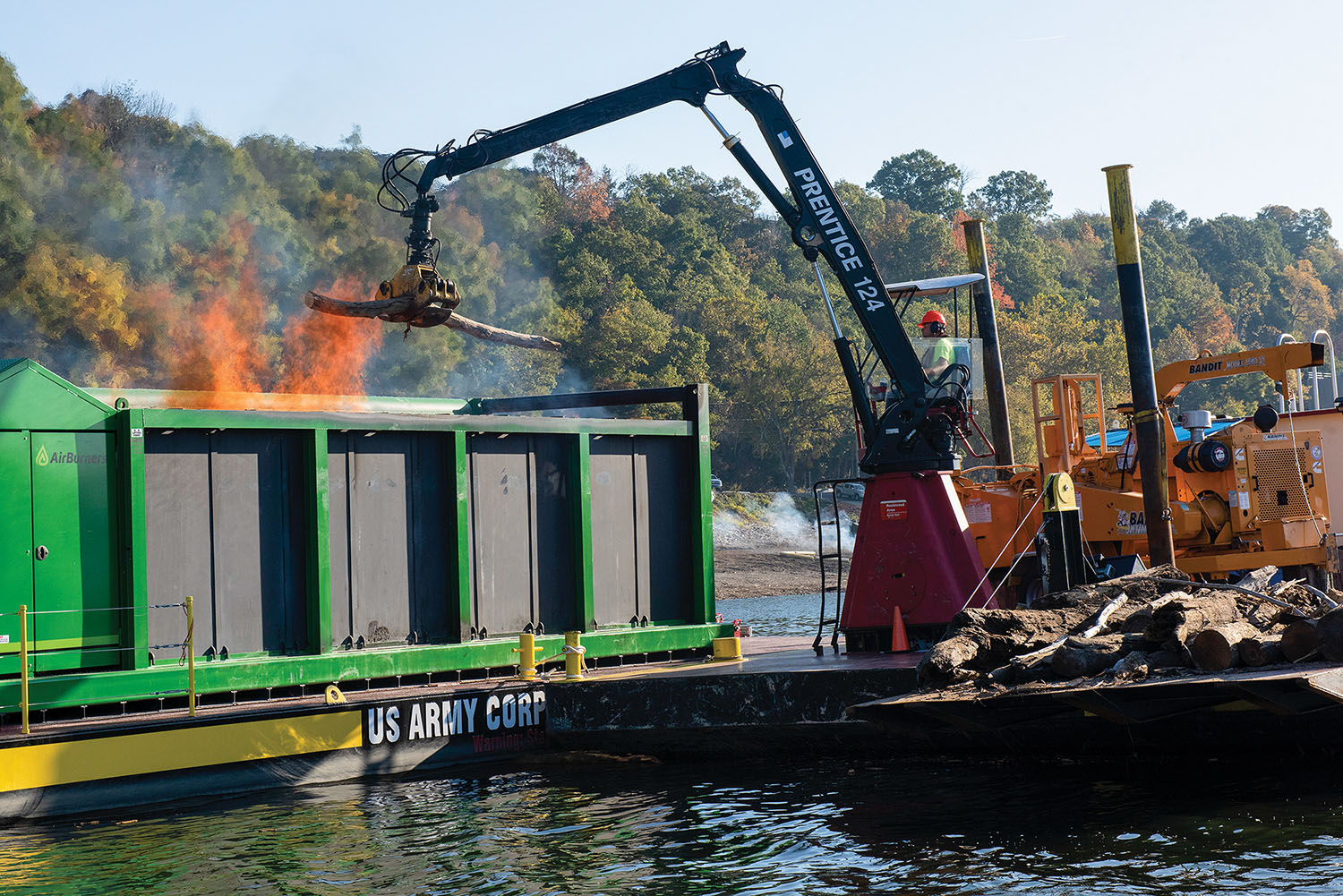 Lead Operator Jesse Neal operates the grapple crane on the PRIDE of the Cumberland, placing debris into an air curtain burner on a new floating barge in Lake Cumberland near Waitsboro Recreation Area in Somerset, Ky. (Photo by Lee Roberts, Nashville Engineer District)