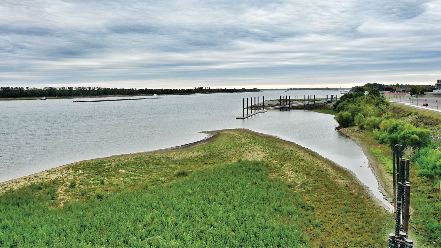 A sediment deposit in the Ohio River at Paducah, Ky., has been greatly exacerbated by prolonged high-water conditions the past three years, according to the city engineer. It has impeded one business’s ability to offload hot liquid asphalt and is now endangering the city’s newly built transient dock for visiting boaters. (Photo by Vick Patel, Paducah Drone)