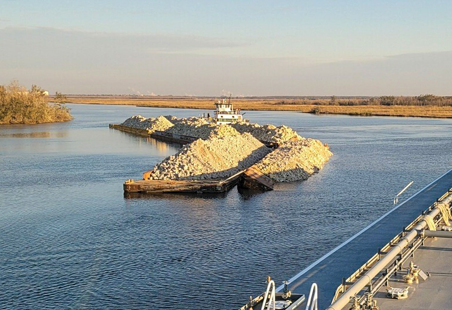 The lead port barge of a six-barge tow is partially submerged near GIWW Mile 235.