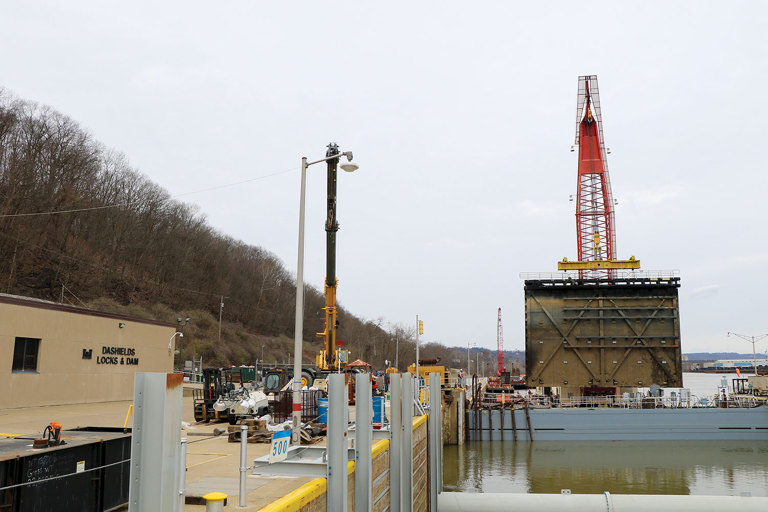 The Corps of Engineers’ heavy lift derrick boat lifts one leaf of the downstream main chamber miter gate for repairs in 2018 at Dashields Lock and Dam on the Ohio River. Auxiliary chambers at Dashields, Montgomery and Emsworth locks and dams will be replaced as part of the Upper Ohio River Navigation Project. (Photo courtesy of Pittsburgh Engineer District)