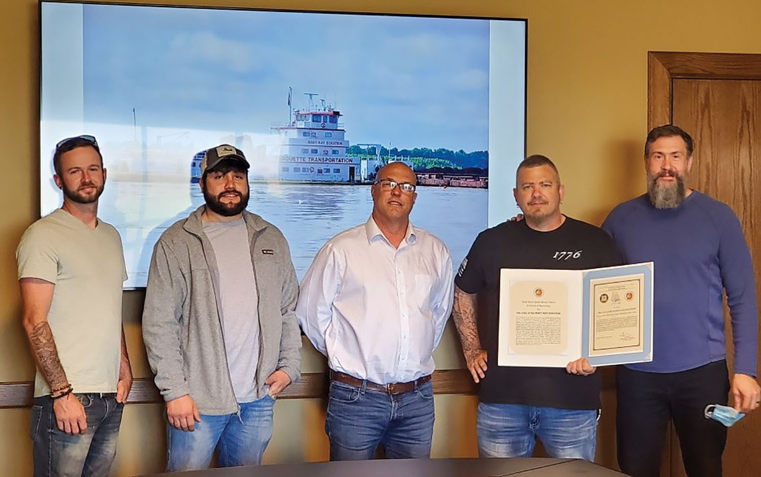 The Coast Guard has honored the crew of the mv. Mary Kay Eckstein with a public service award certificate of appreciation in connection with three separate rescues. Pictured (left to right) are Thomas Cottrell, mate; Colby Mitchell, senior mate; Gary Frayser, senior port captain; David Helton, high captain; and Chris Myskowski, Marquette Transportation’s senior vice president of operations, river division. (Photo courtesy of Marquette Transportation)