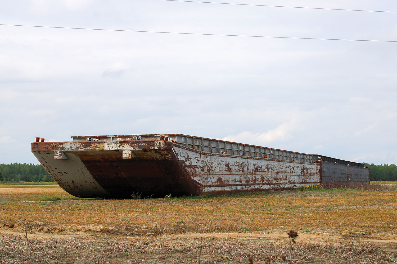 The owner of the land the barges rest on ended up buying them, and now hopes for another flood to refloat them. (Photo by Shelley Byrne)