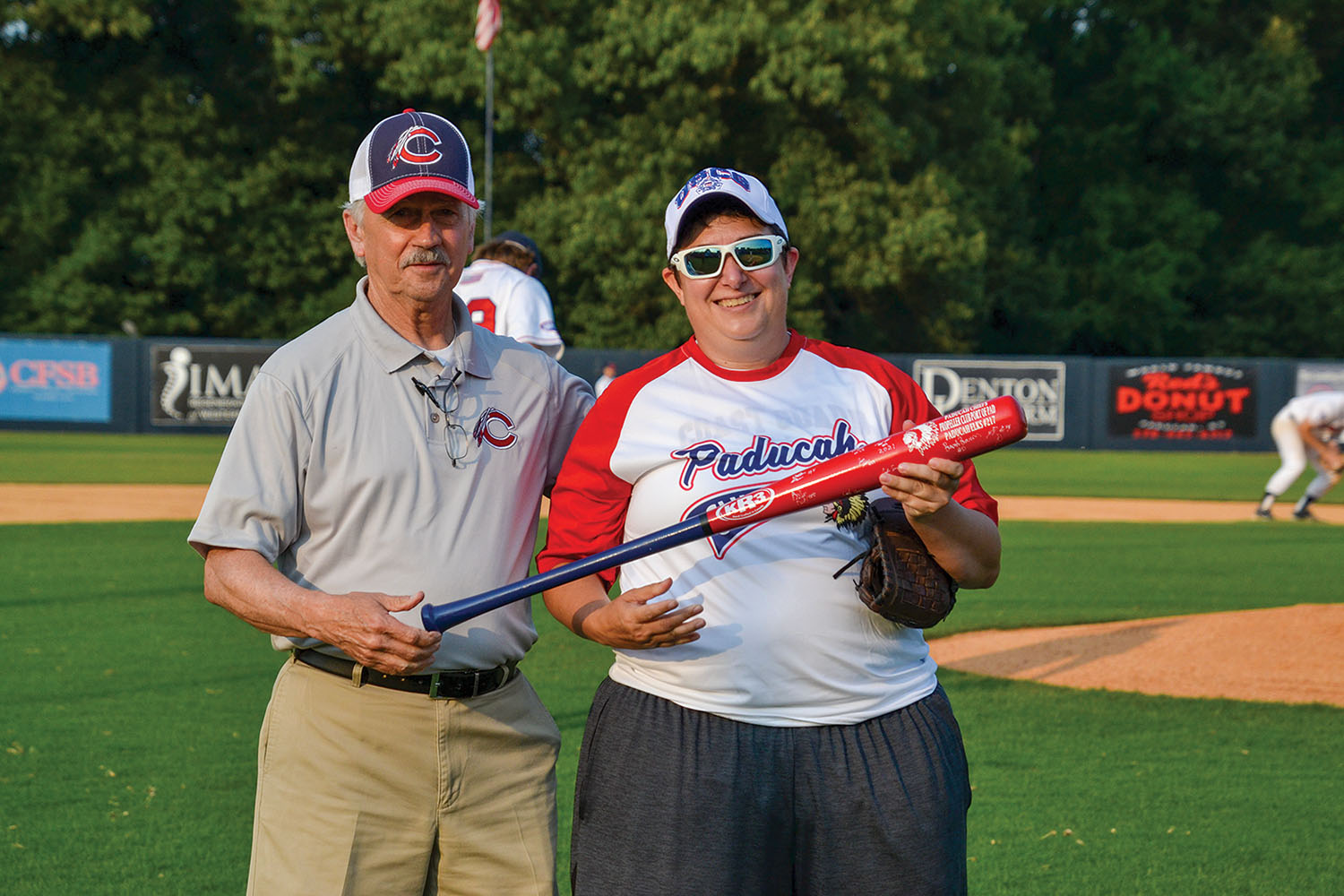 After Cmdr. Jennifer Andrew, MSU Paducah commanding officer, threw out the ceremonial first pitch, Chiefs general manager Greg McKeel presented her with a signed Chiefs bat. (Photo by Gregory Cannon)