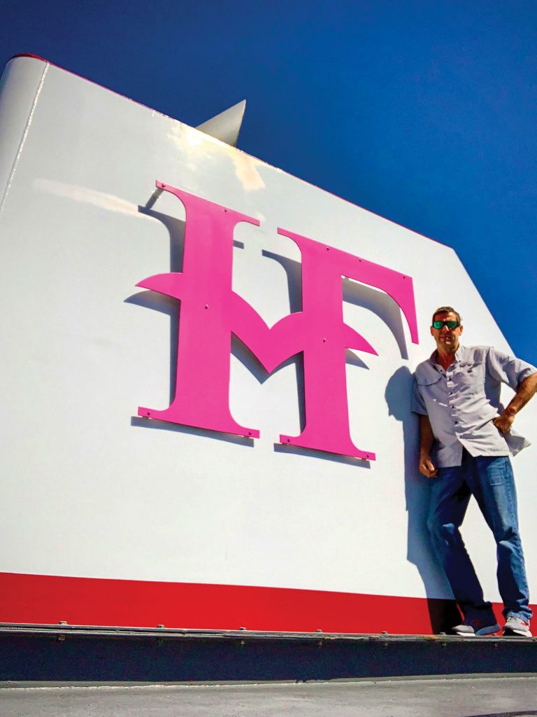 Capt. Robert Tillson stands by the newly painted pink stack logo on the mv. Donna H. Furlong. Tillson had the idea to paint the logo pink in October for national breast cancer awareness month. The idea has now spread to eight Hines Furlong boats, one-third of the company’s fleet. (Photo by Capt. Robert Tillson)