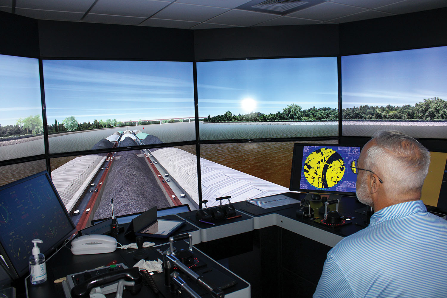 Capt. Mike Coley of Canal Barge Company pilots a tow toward a simulated new Interstate 49 bridge across the Arkansas River. (Photo by Shelley Byrne)