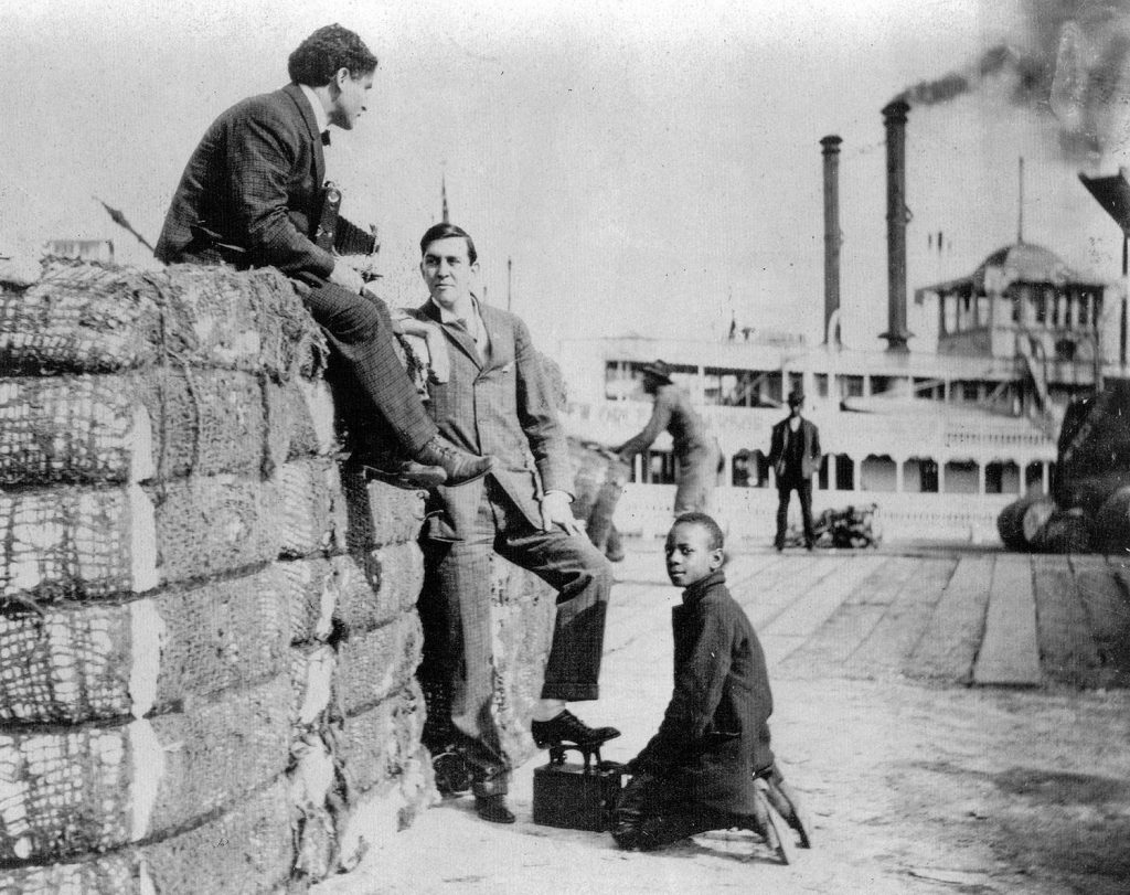 Harry Houdini sitting atop a cotton bale at the foot of Canal Street in New Orleans. The steamboat J.S. is at the wharf. (Keith Norrington collection)