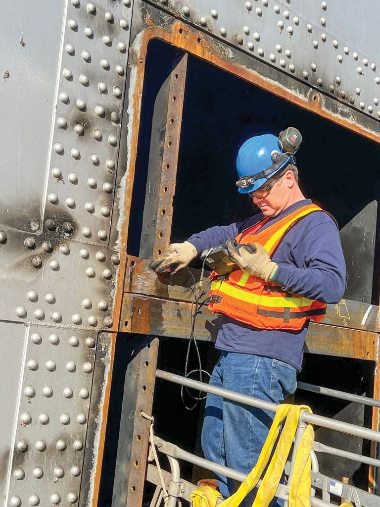 A crew member inspects welding repairs at an upper miter gate at Kentucky Lock. (Photo courtesy of Nashville Engineer District)