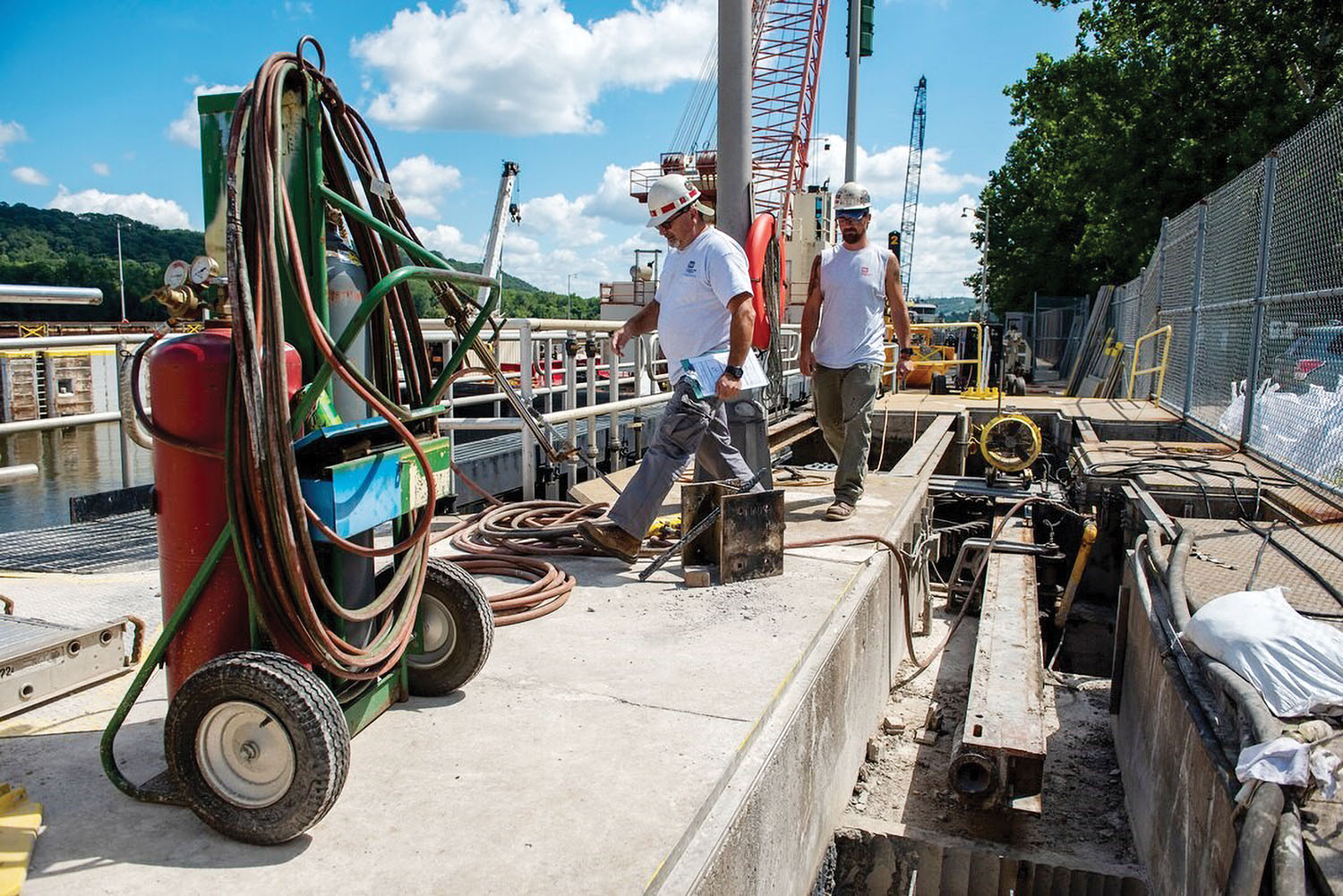 Crewmembers walk across a beam over a hydraulic cylinder pit at the Montgomery Locks and Dam on the Ohio River in Beaver County, Pa. Design and construction of a new lock at Montgomery is fully funded as part of the Corps work plan announced in January. (Photo by Michel Sauret/Pittsburgh Engineer District)