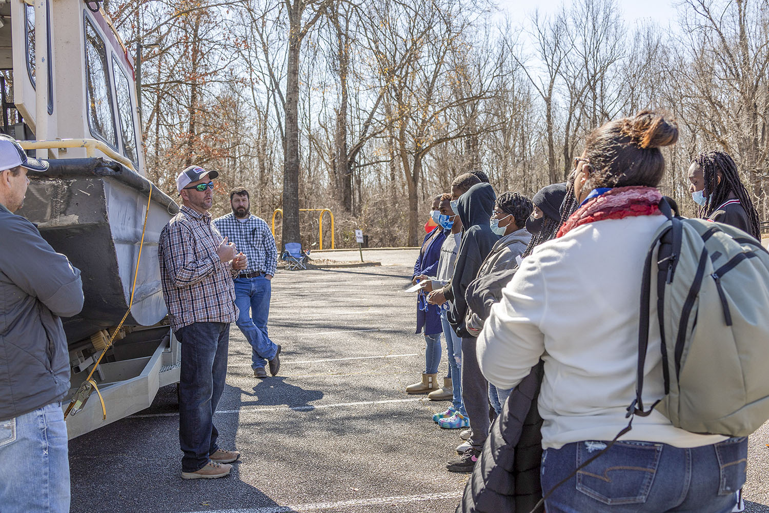 Standing before of a Corps survey boat, Bert Turcotte, Andy Hall and Michael Dale of the Vicksburg Engineer District’s operations department describes for students the careers available in the river operations field. (USACE photo by Vanessa Barnes)