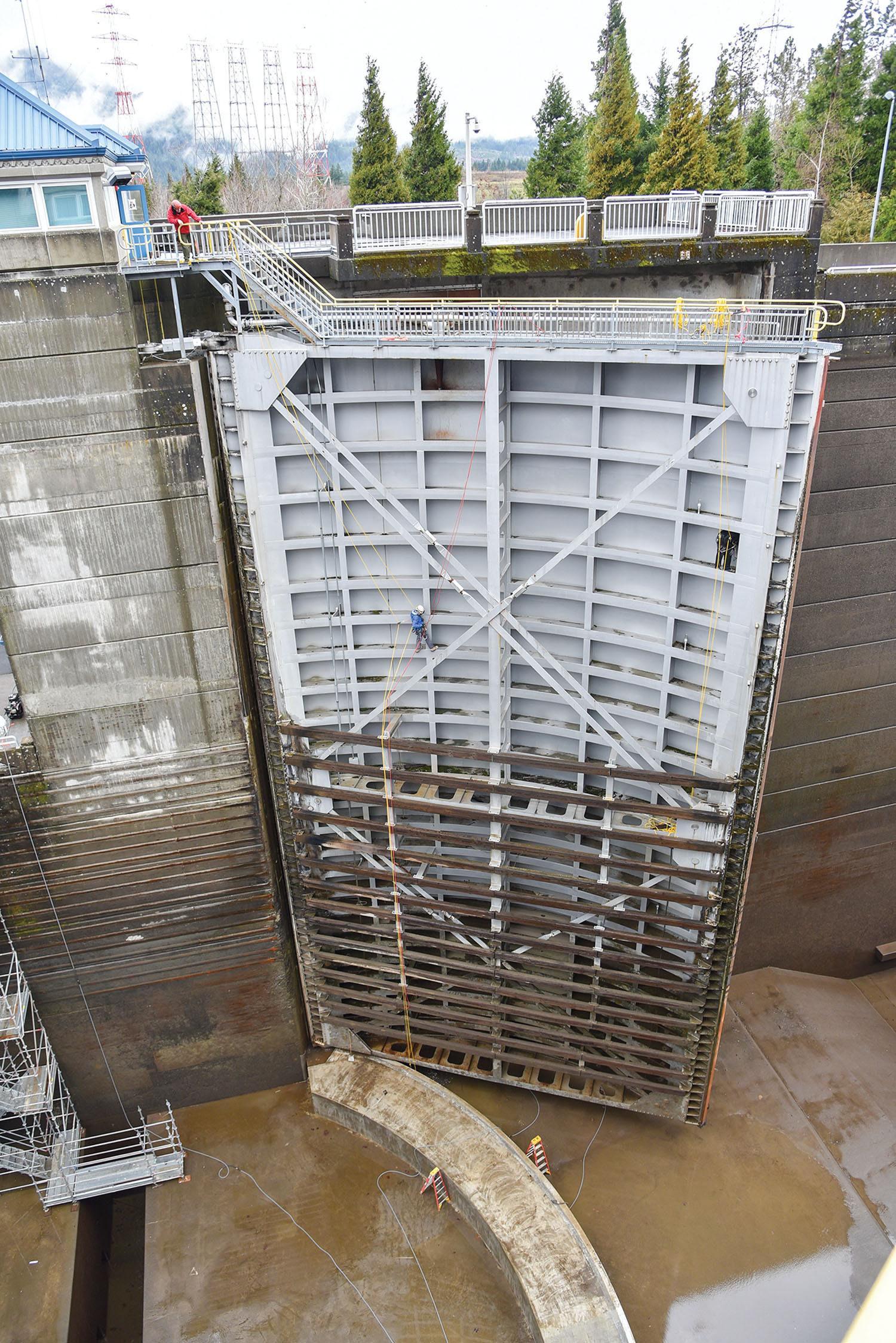 Dwarfed by the massive structure, divers inspect a downstream navigation lock gate during an annual lock outage at Bonneville Lock on the Columbia River. (Photo courtesy of Portland Engineer District)