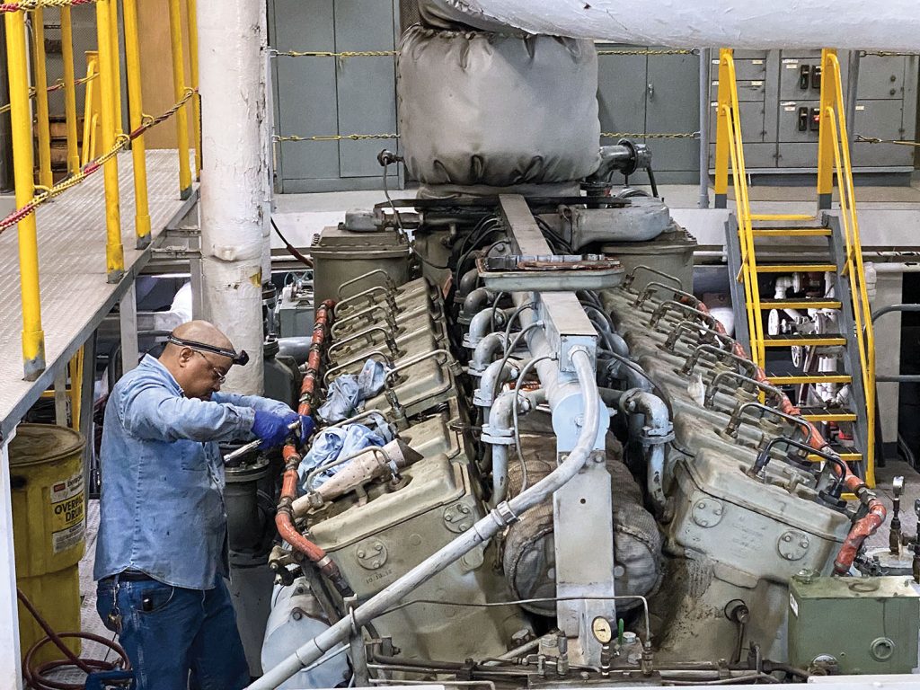 Maintenance on the Dredge Hurley’s engines. (Photo by Bobby Petty)