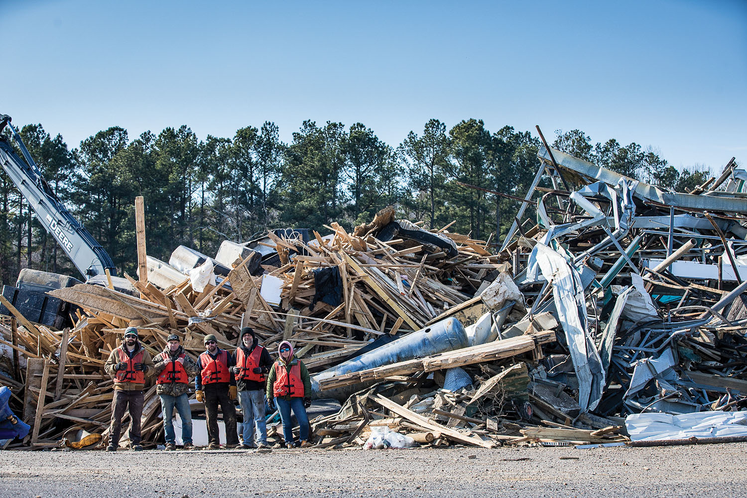 Volunteers from Living Lands & Waters stand in front of a pile of debris cleaned from Kentucky Lake. (Photo by Joel Quimby)