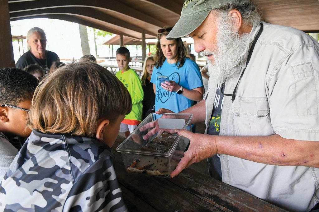 David Withers, a biologist from the Tennessee Department of Environment and Conservation, shows Union Elementary STEAM students a small salamander habitat after teaching them the importance of hydropower to the local wildlife at the Old Hickory Lake picnic area in Hendersonville, Tenn.  (Photo by Misty Cunningham)