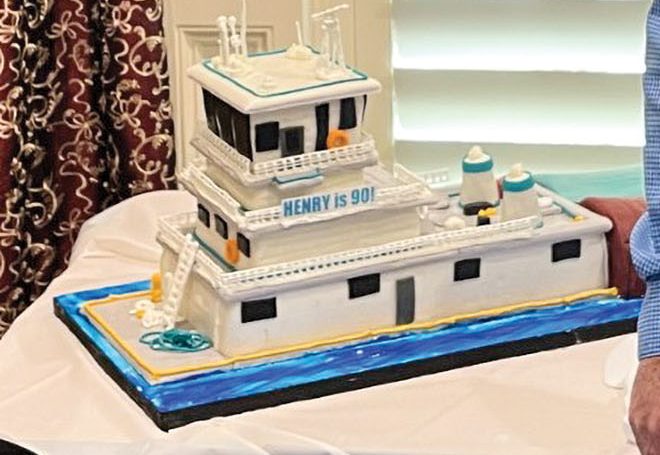 Capt. Henry Elliott celebrated his 90th birthday April 9 with a surprise party and a cake shaped like a towboat and barges. (Photo courtesy of the Elliott family)