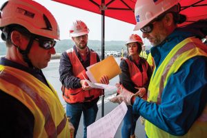 Chris Dening, project manager for construction at Montgomery Locks and Dam, hands out information to company representatives attending the Montgomery Industry Engagement Day.