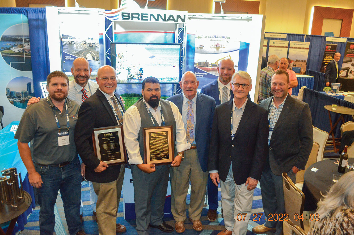 J.F. Brennan associates at the company booth are, from left, Tyler Lee, Matt Binsfeld, Andrew Timmis holding his Dredger of the Year plaque, Michael Cerda holding the company’s safety award, Tony Binsfeld, Mike Binsfeld, Richard Jackson and Greg Smith. (Photo by Judith Powers)