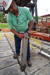 Christopher Johnson, safety and occupational health specialist, demonstrates how a pneumatic tie tool lashes the articulated concrete squares together. (Photo by Frank McCormack)